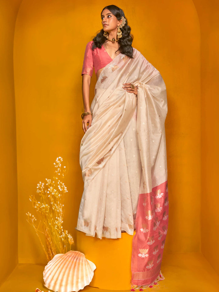 Ivory Cream–Peach Pink feathersoft tussar silk saree featuring woven lotus motifs and soft pallu, styled for festive rituals with a breathable finish. Ivory Cream–Peach Pink feathersoft tussar silk saree featuring woven lotus motifs and soft pallu, styled for festive rituals with a breathable finish..