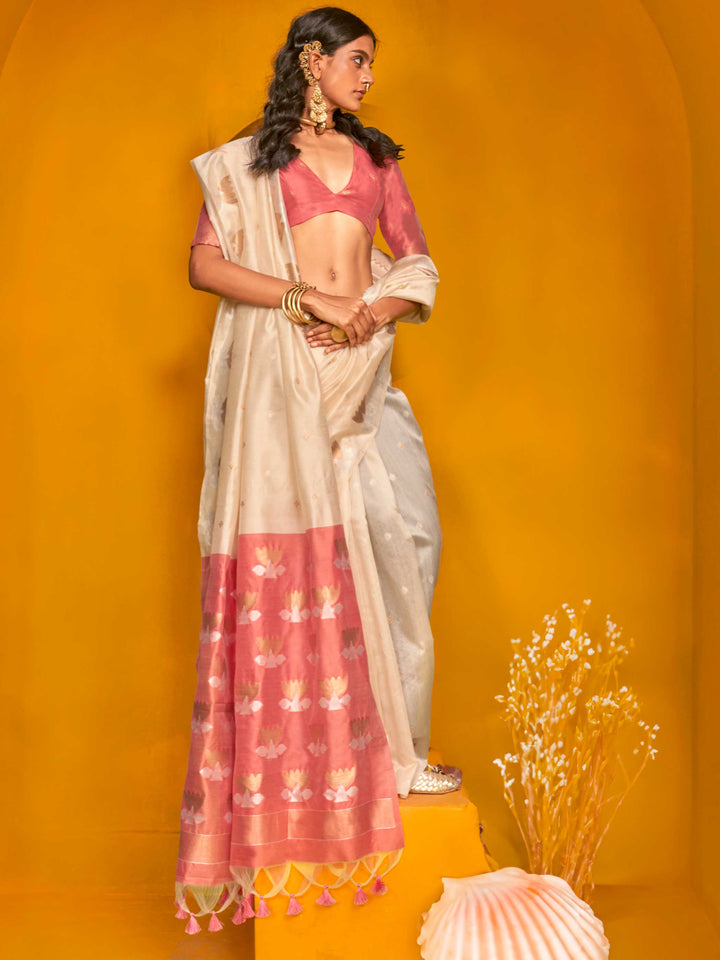 Ivory Cream–Peach Pink feathersoft tussar silk saree featuring woven lotus motifs and soft pallu, styled for festive rituals with a breathable finish.