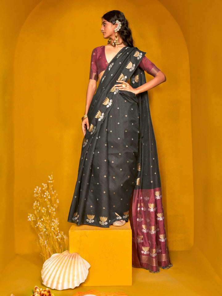 Charcoal Black–Wine Purple feathersoft tussar silk saree featuring woven lotus motifs and soft pallu, styled for festive rituals with a breathable finish. Charcoal Black–Wine Purple feathersoft tussar silk saree featuring woven lotus motifs and soft pallu, styled for festive rituals with a breathable finish..