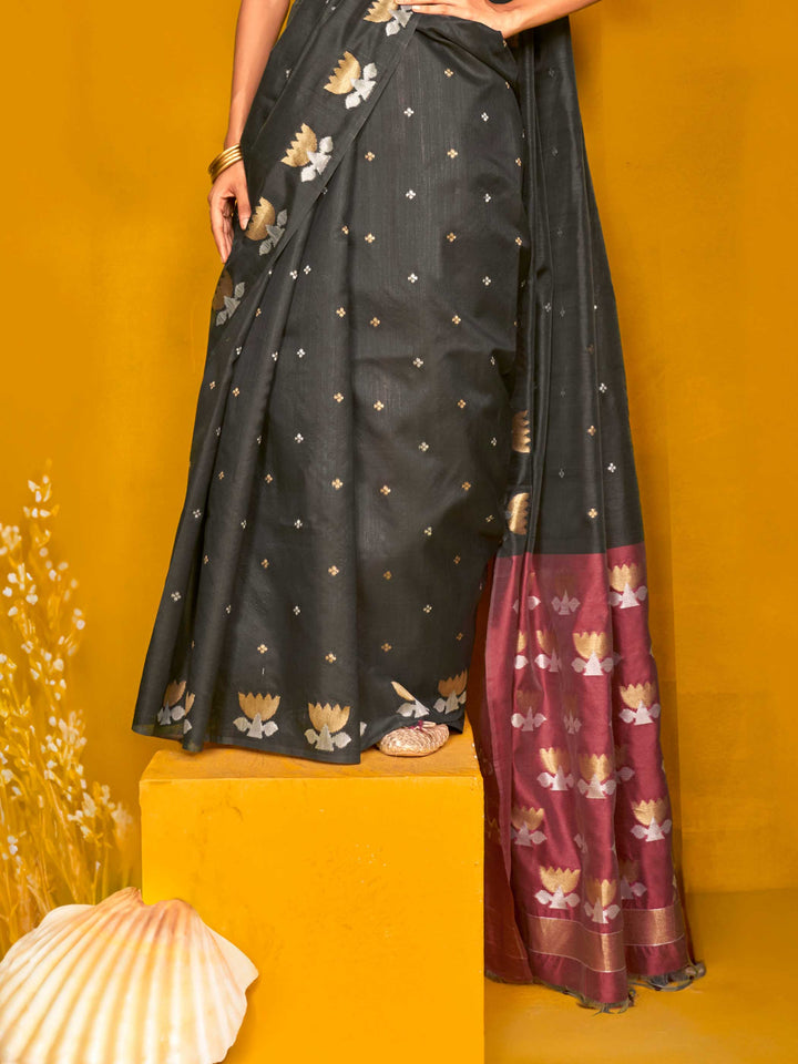 Charcoal Black–Wine Purple feathersoft tussar silk saree featuring woven lotus motifs and soft pallu, styled for festive rituals with a breathable finish. Charcoal Black–Wine Purple feathersoft tussar silk saree featuring woven lotus motifs and soft pallu, styled for festive rituals with a breathable finish..