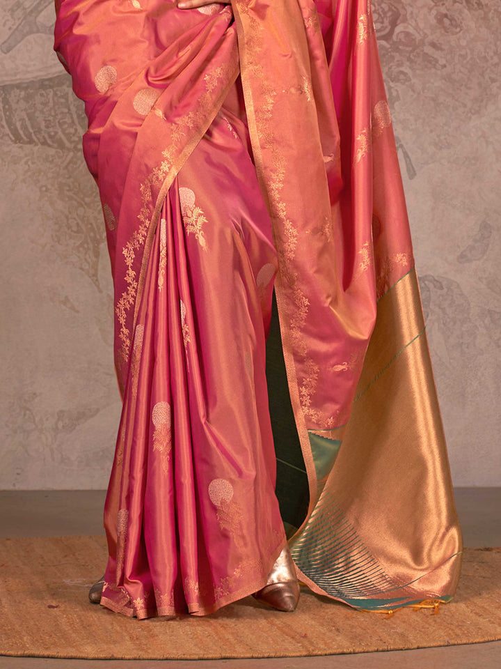 Rani Pink–Golden Peach two-tone satin silk saree with woven zari work, styled for bridal wedding ceremonies with jacquard pattern and contrast pallu elegance. Rani Pink–Golden Peach two-tone satin silk saree with woven zari work, styled for bridal wedding ceremonies with jacquard pattern and contrast pallu elegance..