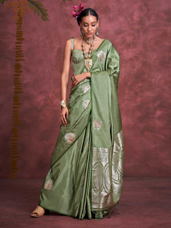 Sage Green–Silver Olive satin silk saree with intricate jacquard zari motifs and metallic pallu, styled for wedding reception and festive bridal evenings with sculpted blouse elegance. Sage Green–Silver Olive satin silk saree with intricate jacquard zari motifs and metallic pallu, styled for wedding reception and festive bridal evenings with sculpted blouse elegance..