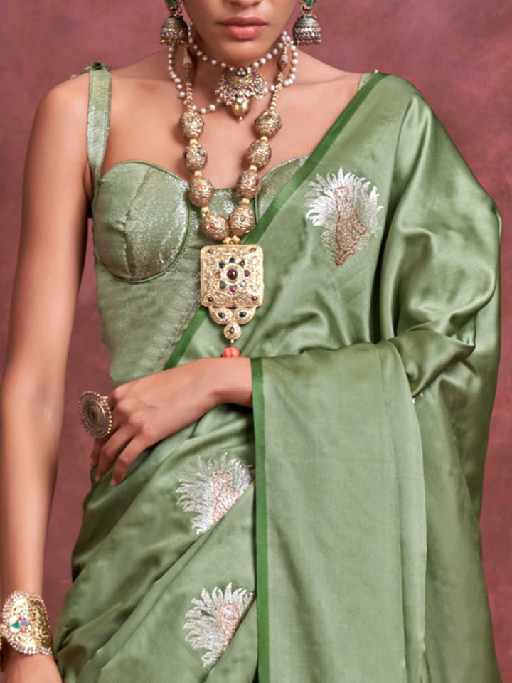 Sage Green–Silver Olive satin silk saree with intricate jacquard zari motifs and metallic pallu, styled for wedding reception and festive bridal evenings with sculpted blouse elegance. Sage Green–Silver Olive satin silk saree with intricate jacquard zari motifs and metallic pallu, styled for wedding reception and festive bridal evenings with sculpted blouse elegance..