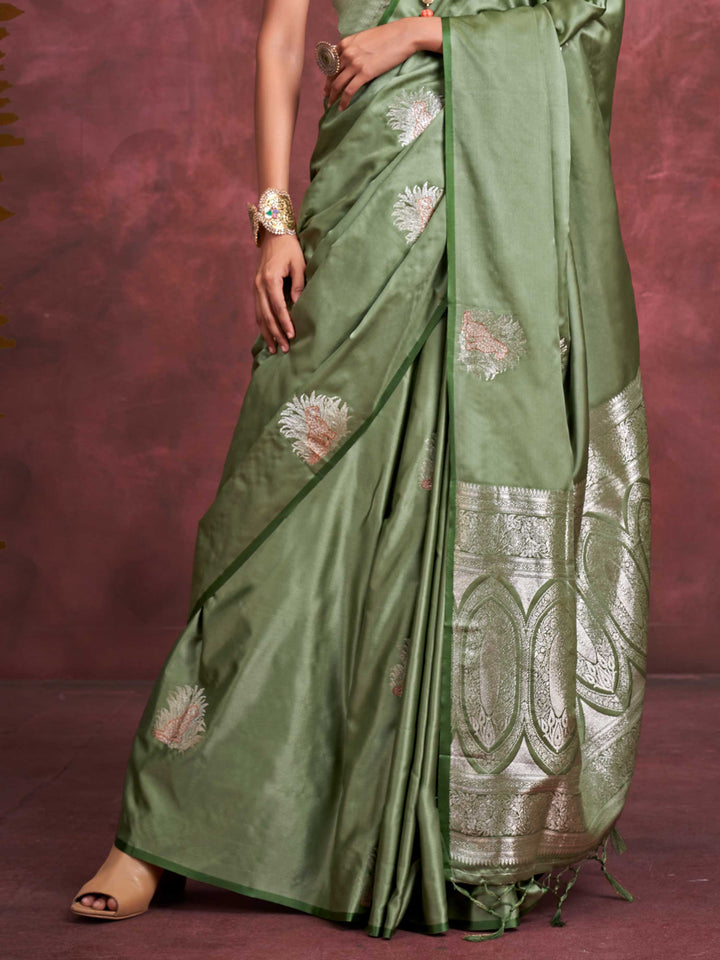Sage Green–Silver Olive satin silk saree with intricate jacquard zari motifs and metallic pallu, styled for wedding reception and festive bridal evenings with sculpted blouse elegance. Sage Green–Silver Olive satin silk saree with intricate jacquard zari motifs and metallic pallu, styled for wedding reception and festive bridal evenings with sculpted blouse elegance..