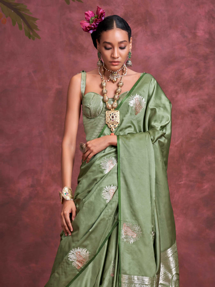 Sage Green–Silver Olive satin silk saree with intricate jacquard zari motifs and metallic pallu, styled for wedding reception and festive bridal evenings with sculpted blouse elegance. Sage Green–Silver Olive satin silk saree with intricate jacquard zari motifs and metallic pallu, styled for wedding reception and festive bridal evenings with sculpted blouse elegance..