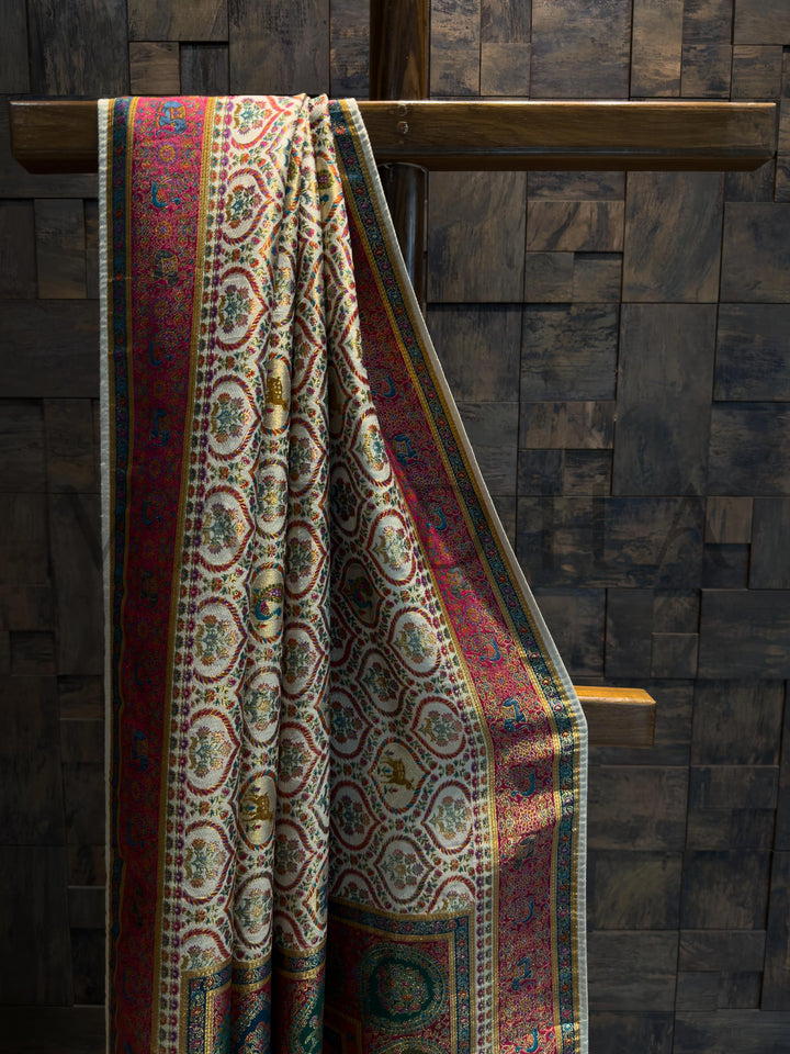 Saree draped over a wooden chair against a dark stone wall.