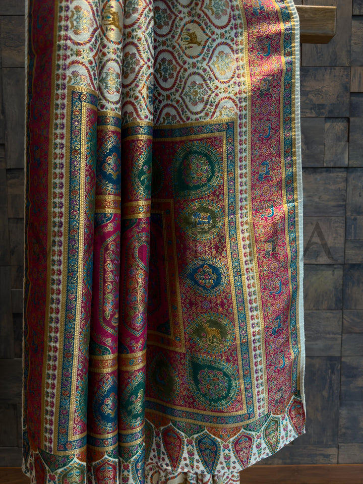 Cream saree draped over a wooden surface with a wooden wall background