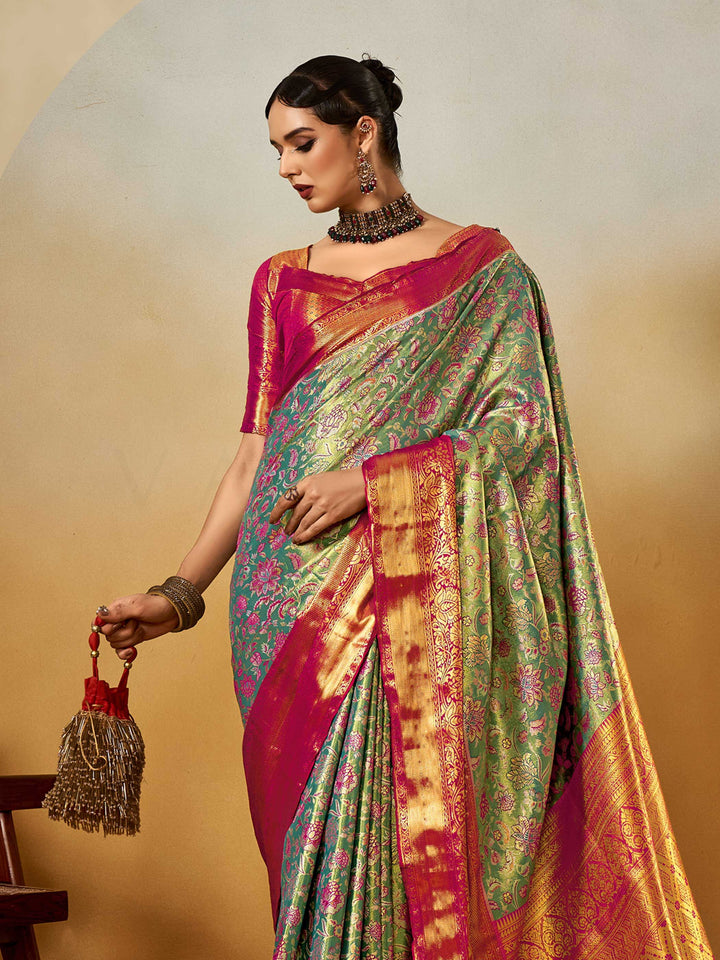 Sea Green–Rani Pink Banarasi satin silk saree with zari work and woven parrot motifs, styled for traditional Indian wedding rituals with luxury finish. Sea Green–Rani Pink Banarasi satin silk saree with zari work and woven parrot motifs, styled for traditional Indian wedding rituals with luxury finish..