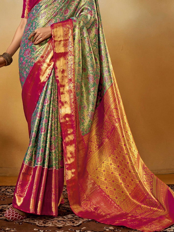Sea Green–Rani Pink Banarasi satin silk saree with zari work and woven parrot motifs, styled for traditional Indian wedding rituals with luxury finish. Sea Green–Rani Pink Banarasi satin silk saree with zari work and woven parrot motifs, styled for traditional Indian wedding rituals with luxury finish..