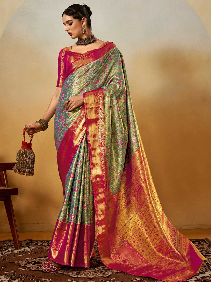 Sea Green–Rani Pink Banarasi satin silk saree with zari work and woven parrot motifs, styled for traditional Indian wedding rituals with luxury finish. Sea Green–Rani Pink Banarasi satin silk saree with zari work and woven parrot motifs, styled for traditional Indian wedding rituals with luxury finish..
