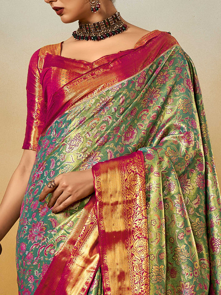 Sea Green–Rani Pink Banarasi satin silk saree with zari work and woven parrot motifs, styled for traditional Indian wedding rituals with luxury finish. Sea Green–Rani Pink Banarasi satin silk saree with zari work and woven parrot motifs, styled for traditional Indian wedding rituals with luxury finish..