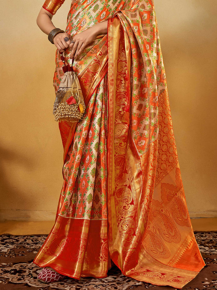 Orange–Gold Banarasi satin silk saree with zari work and woven parrot motifs, styled for traditional Indian wedding rituals with luxury finish. Orange–Gold Banarasi satin silk saree with zari work and woven parrot motifs, styled for traditional Indian wedding rituals with luxury finish..