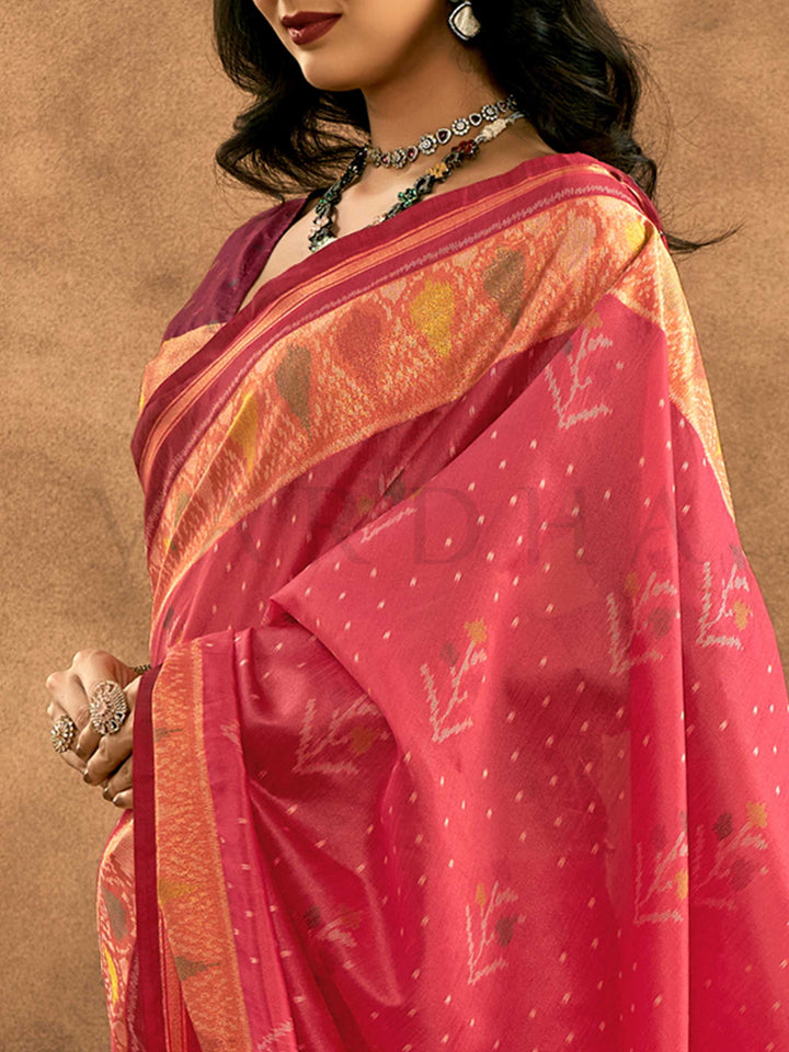 Crimson Pink–Burnt Orange Banarasi silk saree with Patola-inspired design and rich zari border, styled for wedding glamour and traditional elegance. Crimson Pink–Burnt Orange Banarasi silk saree with Patola-inspired design and rich zari border, styled for wedding glamour and traditional elegance..