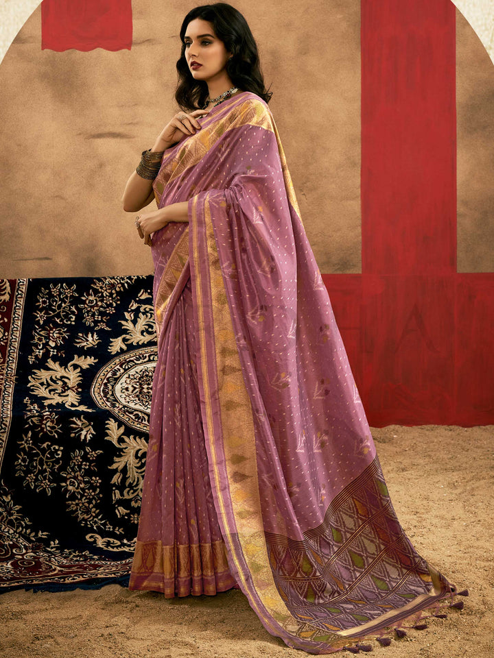 Lavender Mauve–Gold Banarasi silk saree with Patola-inspired design and rich zari border, styled for wedding glamour and traditional elegance. Lavender Mauve–Gold Banarasi silk saree with Patola-inspired design and rich zari border, styled for wedding glamour and traditional elegance..