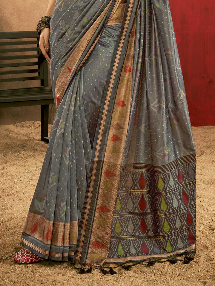 Slate Grey–Multi Zari Banarasi silk saree with Patola-inspired design and rich zari border, styled for wedding glamour and traditional elegance. Slate Grey–Multi Zari Banarasi silk saree with Patola-inspired design and rich zari border, styled for wedding glamour and traditional elegance..