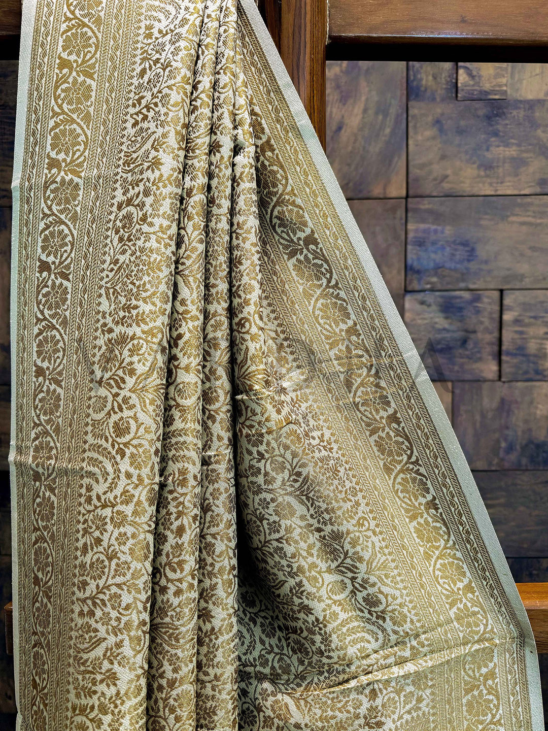 Wide shot of saree highlighting full drape and subtle gold-beige tone with lustrous zari finish. Temple-style zari border with fine floral weaving in antique gold thread on beige viscose base.