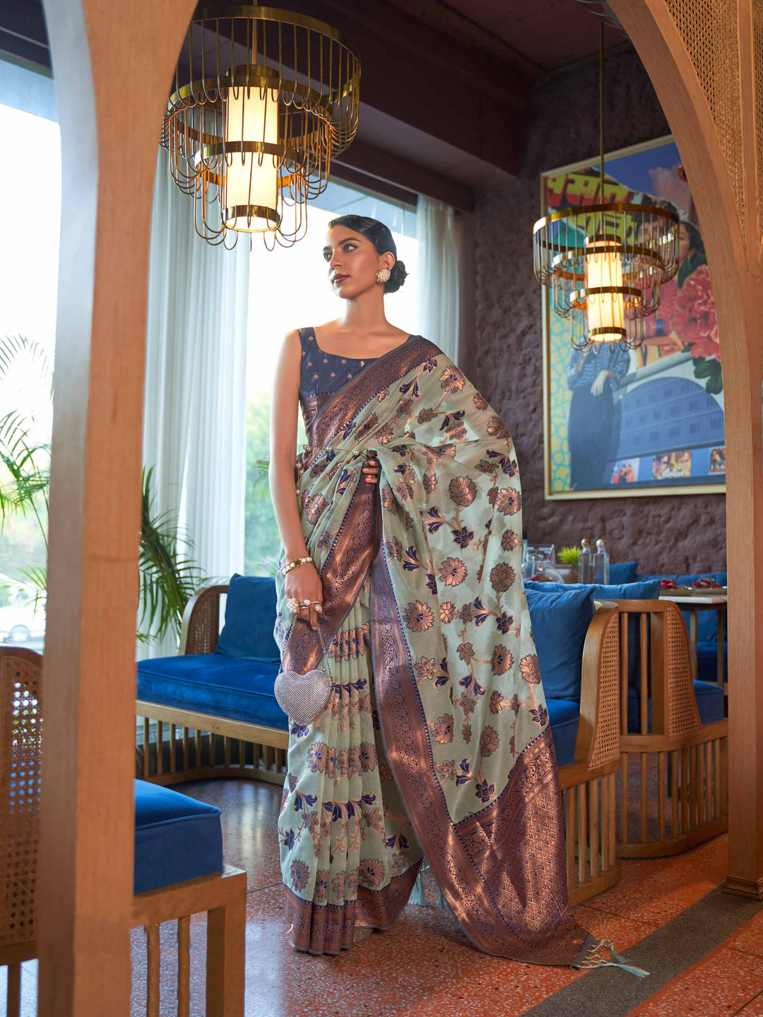 Blue Shimmer Organza Saree with Copper Zari Weaving and Contrast Border, featuring an Exquisite Floral Jangla Design—a perfect blend of Traditional Craftsmanship and Modern Elegance for Festive Occasions.