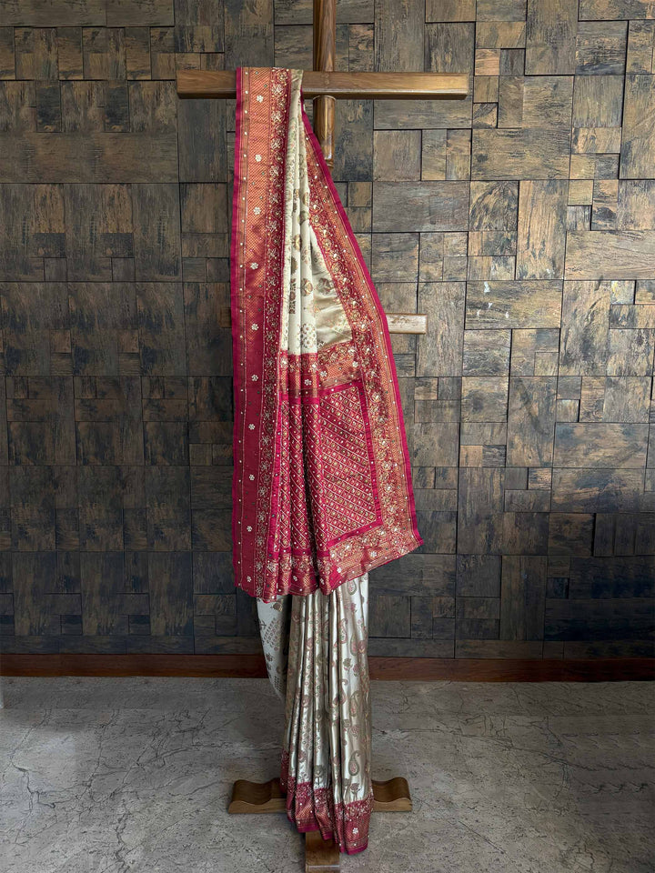A stunning Cream Wine Kalamkari Silk Saree featuring intricate handwoven zari work, delicate floral motifs, and a rich silk texture. The saree is paired with a matching blouse, making it an elegant choice for weddings and festive occasions.