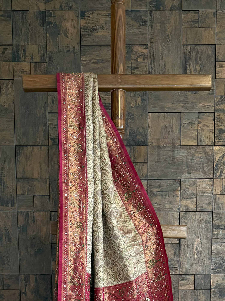 The luxurious Cream-Wine Kalamkari Saree with intricate Zari Work and hand embellishments celebrates heritage with modern flair. Perfect for grand occasions, it exudes elegance and is sure to make you the center of attention at any event.