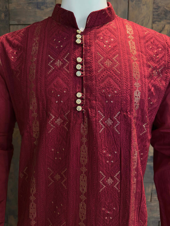 Maroon embroidered kurta on a mannequin against a wooden background Front panel detail of men’s viscose kurta featuring woven columns, diamond motifs and elegant sequin accents for weddings and celebrations.
