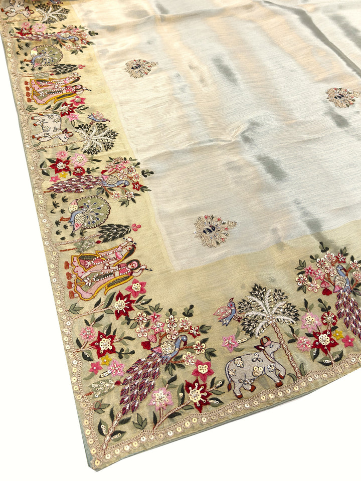 Embroidered fabric with floral and peacock designs on a beige background