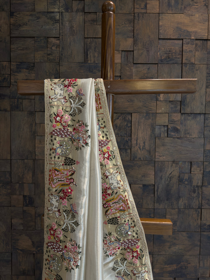 Embroidered fabric draped over a wooden cross against a brick wall.