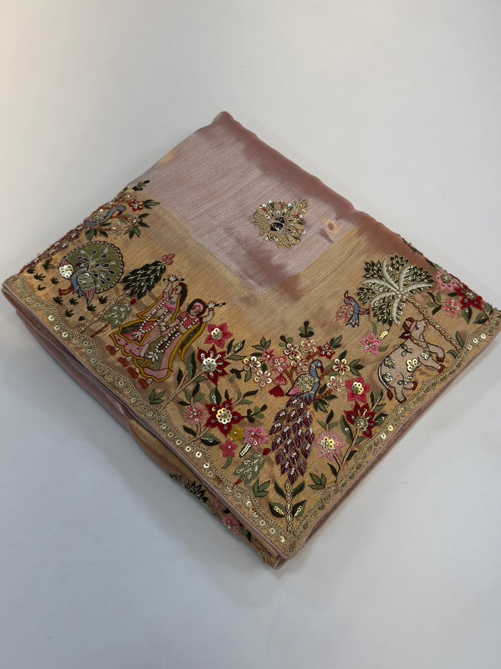 Zoomed border of pink silk saree featuring peacocks, cows, palm trees, and mirror embroidery perfect for sacred festive occasions.