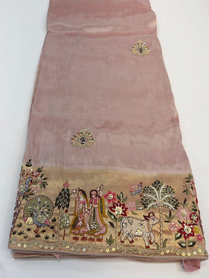 Saree pallu with Radha Krishna embroidery surrounded by sequined flora and fauna, a symbol of divine love in ethnic attire.