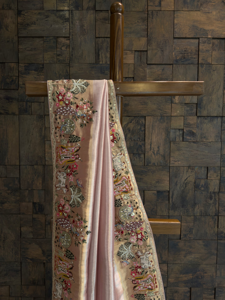 Decorative fabric with floral patterns hanging on a wooden rod against a stone wall.