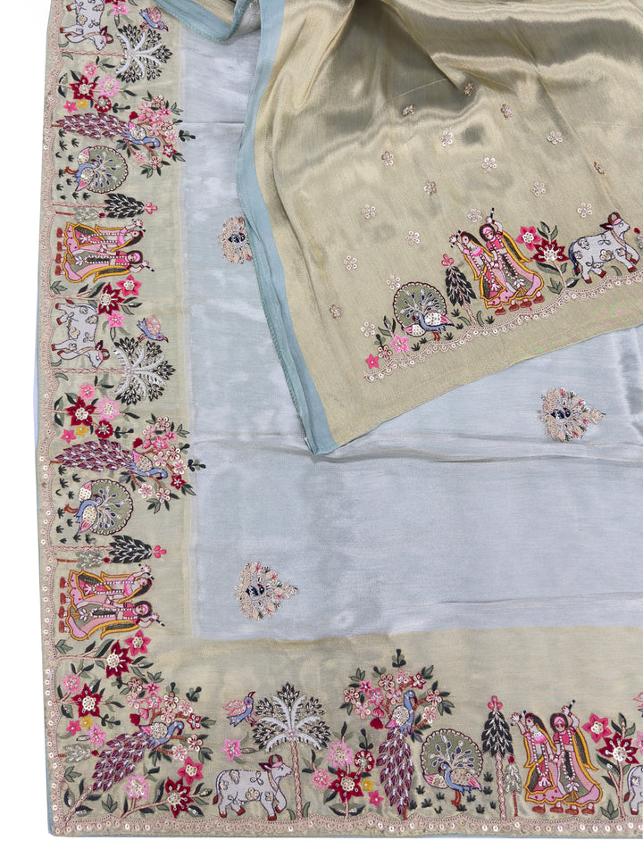 Full saree view with Radha Krishna hand embroidery and floral vines across light green tissue silk, perfect for temple or haldi functions.