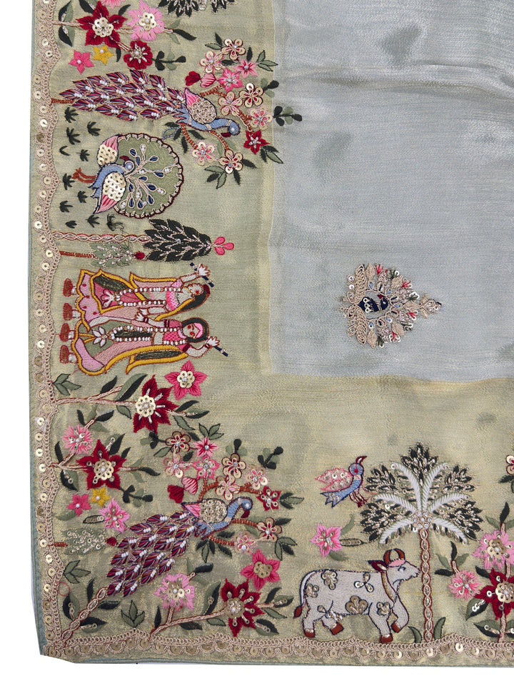 Close-up of zari butta and mirror sequin detailing across body of dusty green saree capturing cultural storytelling and elegance.