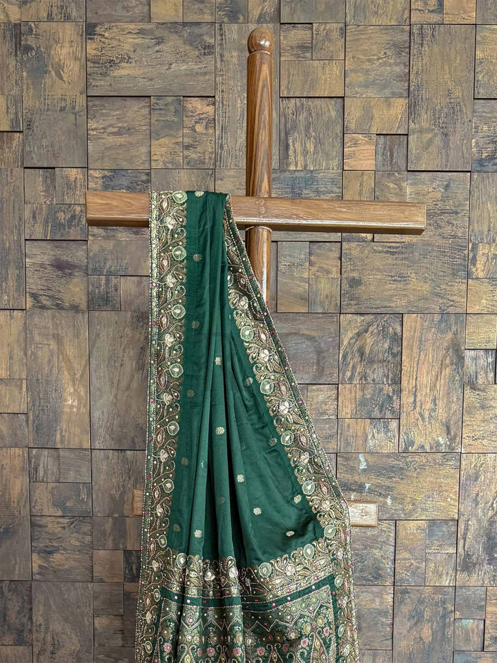Regal emerald green Banarasi satin silk saree with Jamawar motifs and hand-embroidered buttis, ideal for weddings and celebrations.