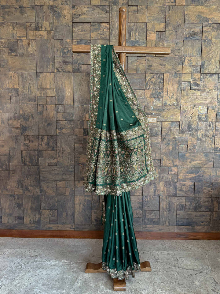 Exquisite Emerald Green Banarasi Jamawar satin silk saree featuring delicate hand-embroidered buttis for a regal and festive look.
