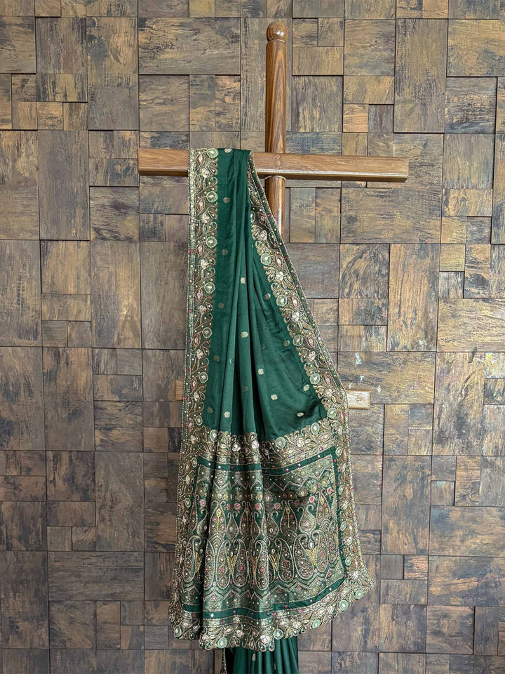 Luxurious Emerald Green Banarasi satin silk saree with traditional Jamawar weaving and intricate hand embroidery buttis, perfect for grand occasions.