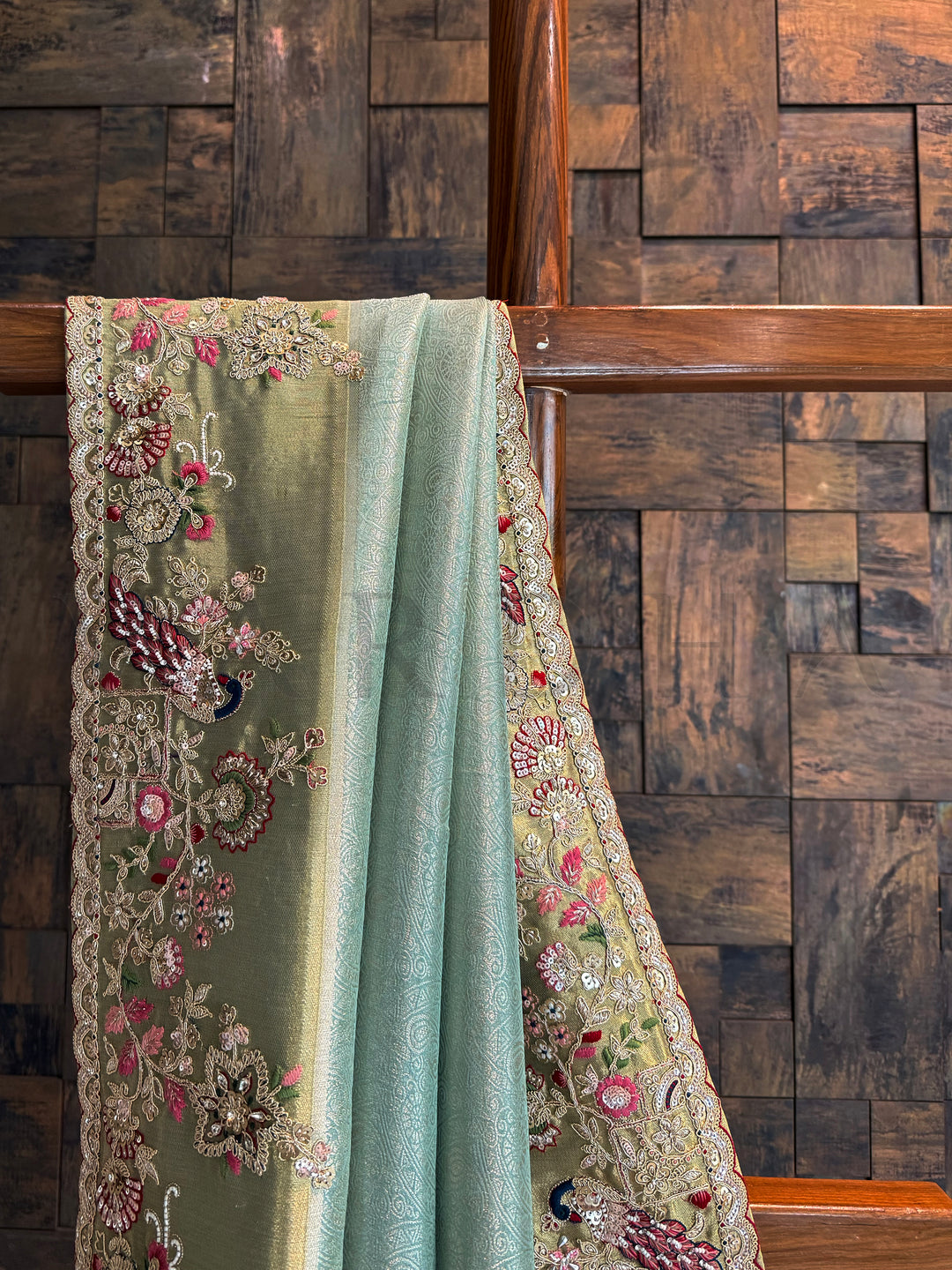 Wedding wear firozi saree decorated with peacock motifs, floral vines, sequins and beads.