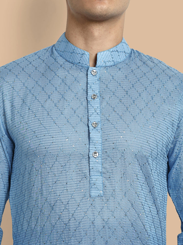 Close-up of placket area showing fine chikankari and glossy sequins on blue kurta fabric