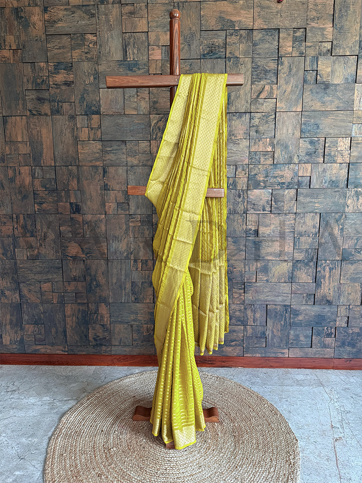 Green georgette saree with golden zari striped body and diamond jaal trellis border, lightweight and elegant for festive occasions