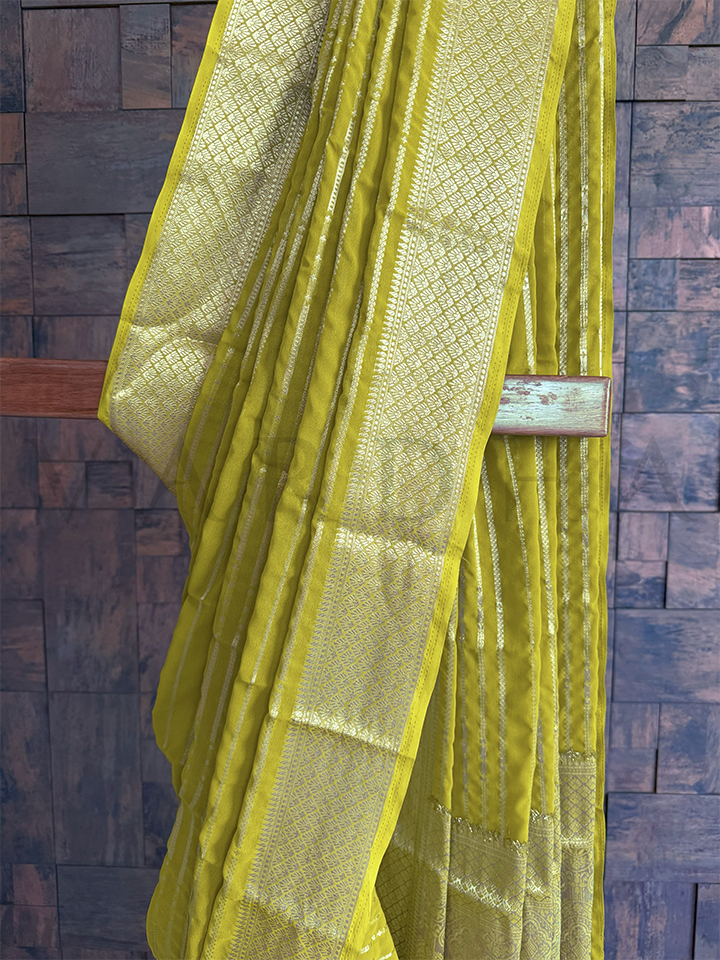 Lightweight green saree in georgette fabric with zari stripes and detailed diamond jaal border design