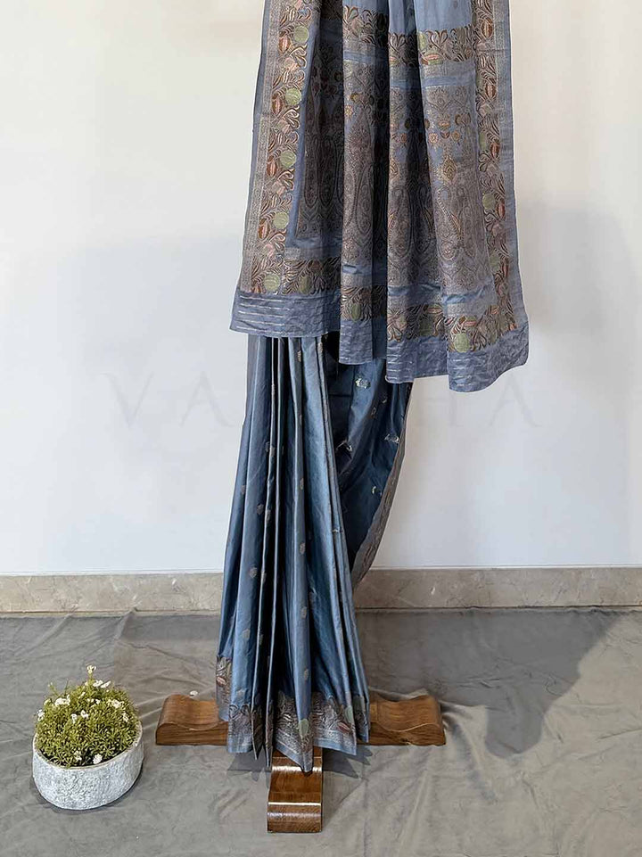Graceful grey Jamawar satin saree with traditional motifs, ideal for weddings and special occasions, blending luxury with culture.