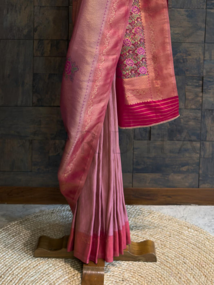 Side view of saree draped over hanger highlighting pastel woven body and digital artistry., Lac pink art silk fabric reflecting soft golden texture with intricate weaving for cultural events