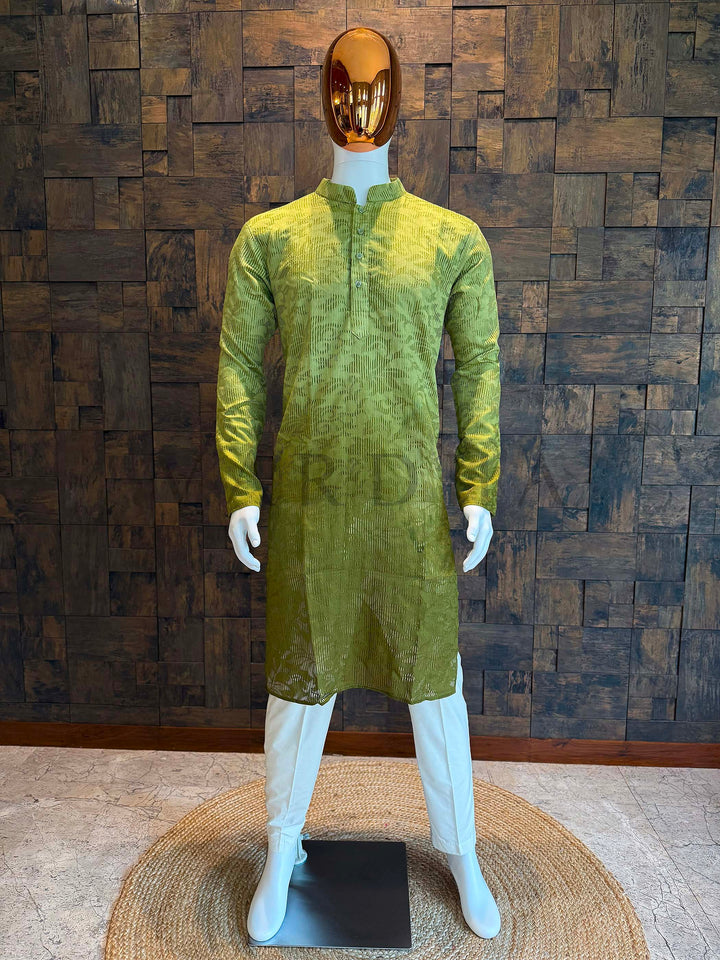 Green kurta on a mannequin against a wooden paneled wall. Teal ombré viscose men’s kurta with mandarin collar and self-textured jacquard pattern, fading to deep charcoal at the hem, styled on mannequin with white churidar.