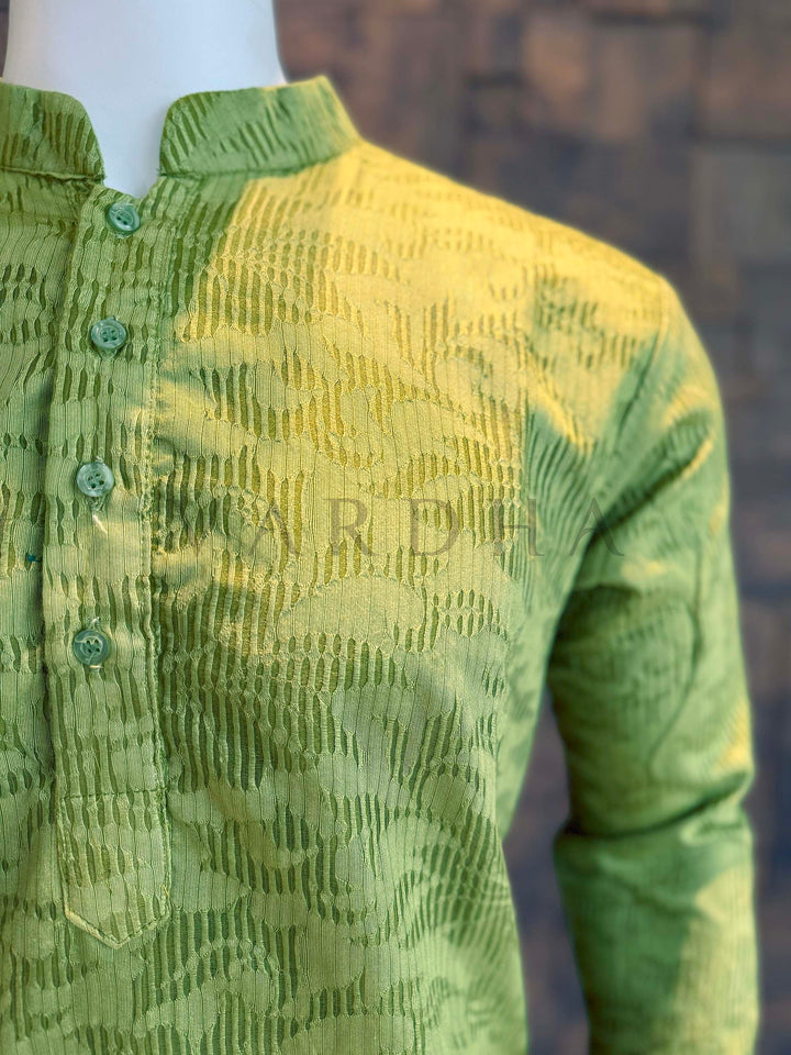 Green textured shirt on a mannequin with a blurred background Macro shot capturing vertical rib jacquard and abstract cloud-like motifs on soft viscose fabric with gentle sheen, in teal-to-charcoal gradient.
