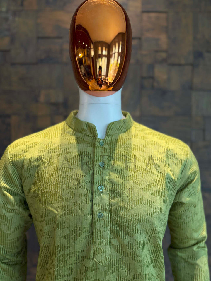 Mannequin wearing a green textured shirt against a textured wall. Macro shot capturing vertical rib jacquard and abstract cloud-like motifs on soft viscose fabric with gentle sheen, in teal-to-charcoal gradient.