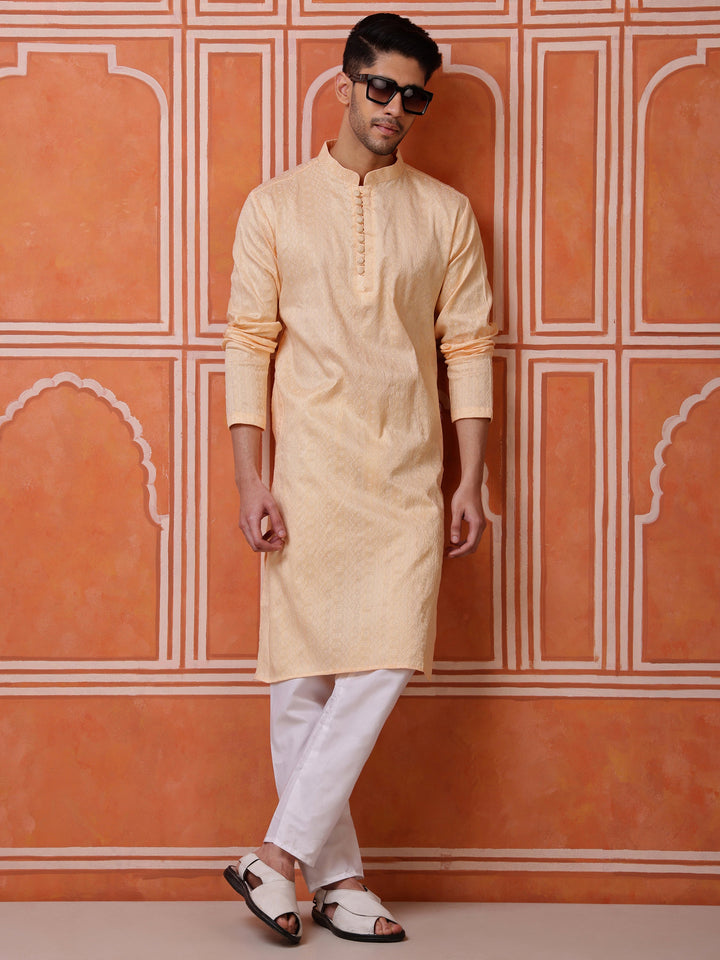 Close-up of the textured jacquard weave and self-colored buttons on the placket of a peach men's kurta