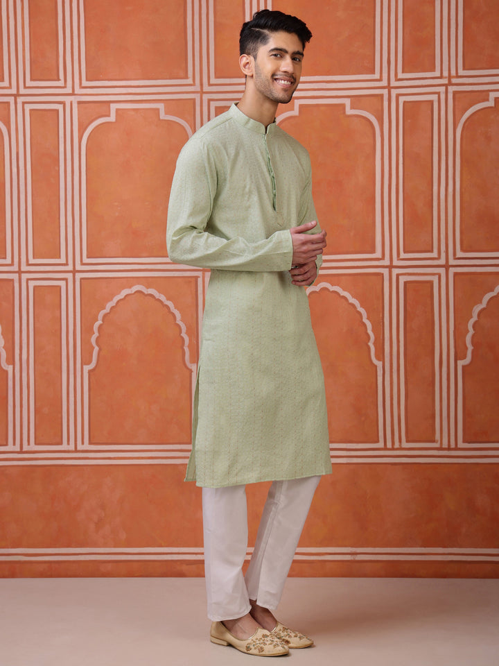 Close-up of the subtle textured weave and minimal threadwork detail on the placket of a light green kurta