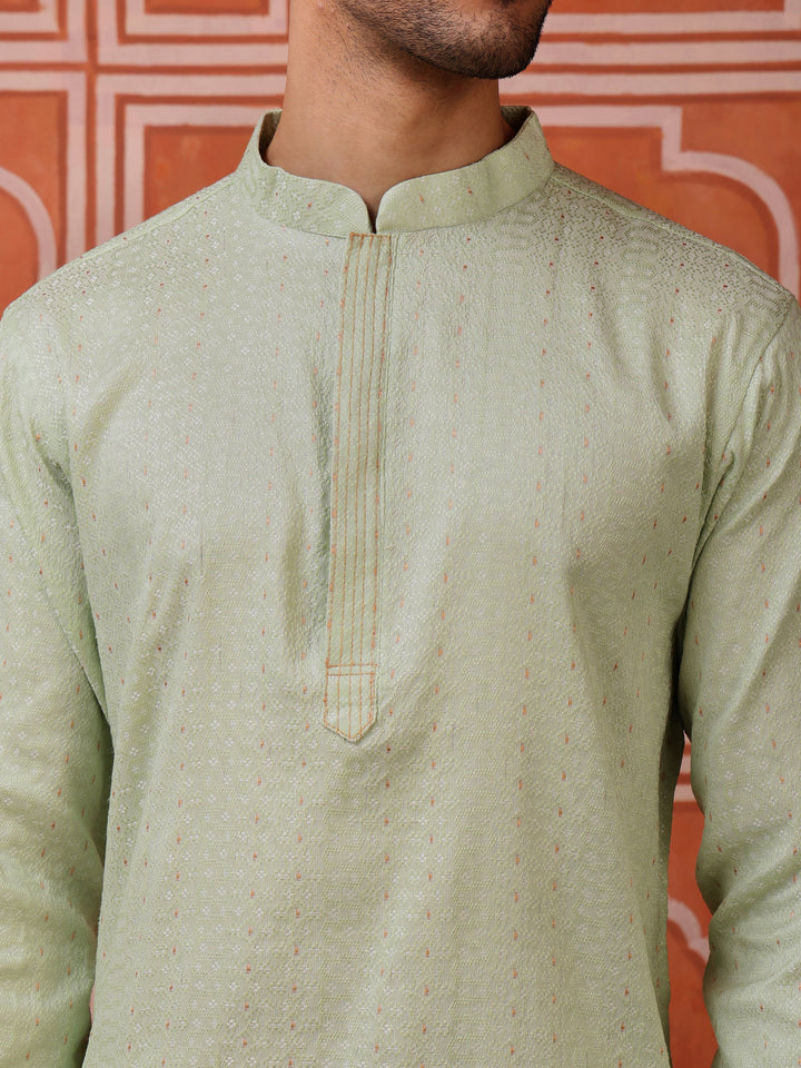 Full view of a man wearing a light green jacquard kurta and white pyjamas, perfect for casual celebrations