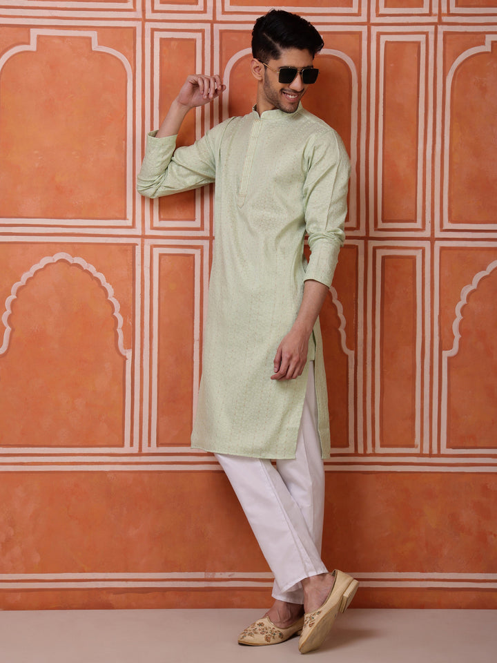 <br\ crockery/vases on shelf in background >---<br>Light green mandarin collar kurta for men in a luxurious silk blend, offering a fresh and modern look