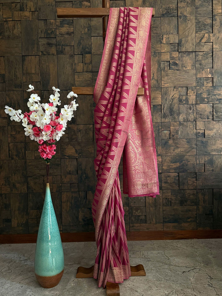 Rose pink soft georgette saree with intricate golden zari pallu for traditional occasions.