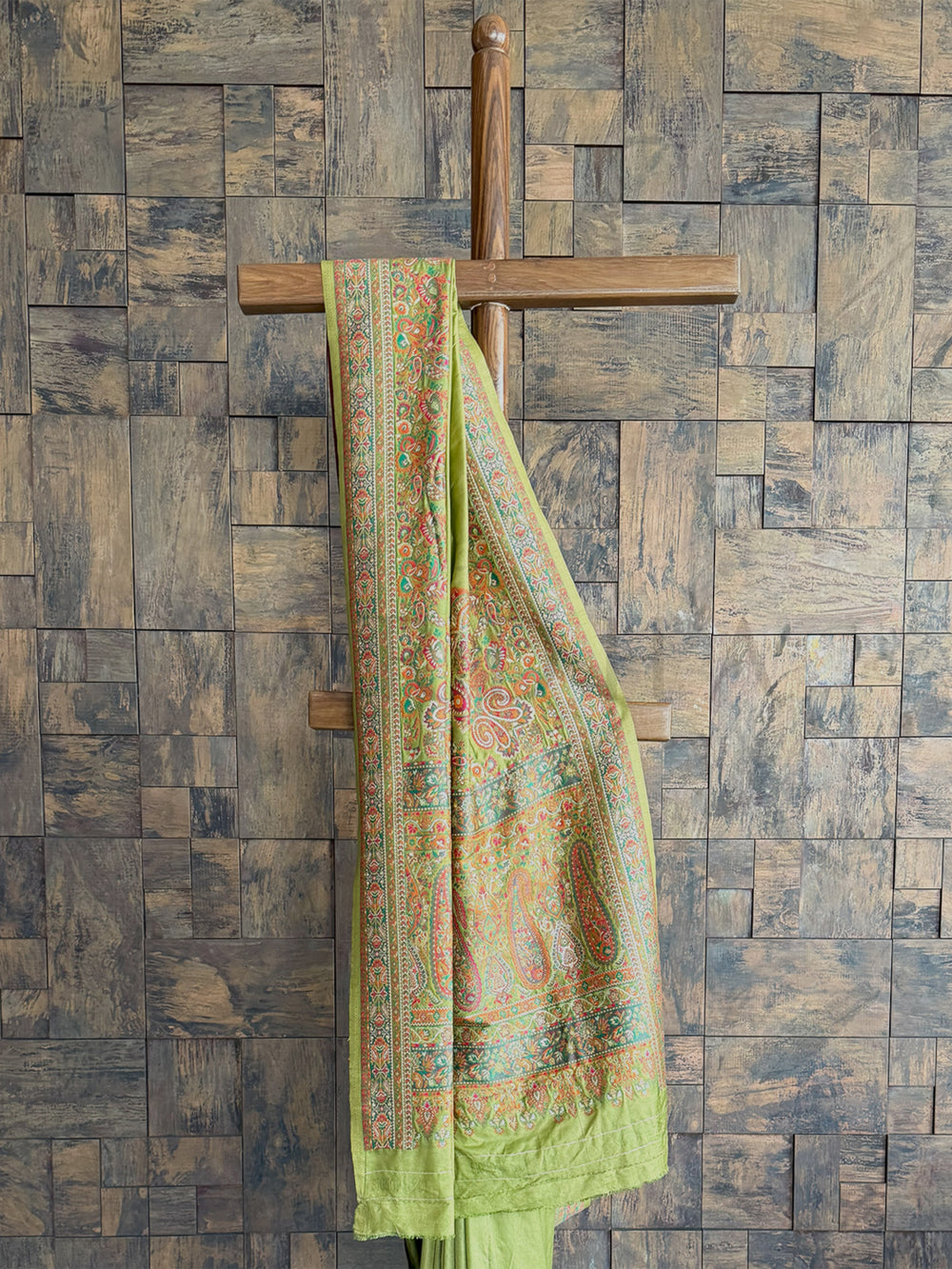 Graceful mehendi green saree in premium Pashmina raw silk, adorned with delicate embossed thread embroidery for a refined appeal.