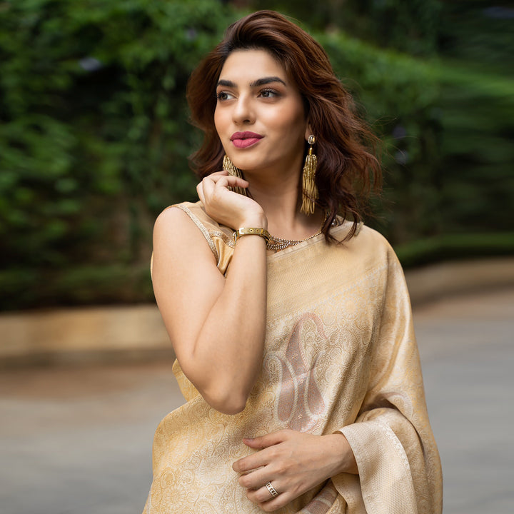 Nikita Dhongdi draped in off-white Kanjeevaram saree with shimmering gold, copper, and silver zari accents.